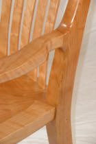 Wooden chair with curved armrest detail.