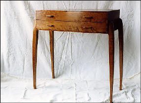 A wooden side table with two drawers and four slender, slightly curved legs, set against a plain white background.