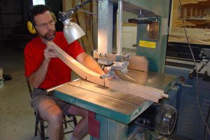 Man using bandsaw to cut wood.