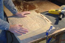 Person working on wood with a tool.