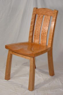 A wooden chair with a solid seat, two vertical back slats, and four straight legs, placed in front of a plain white background.