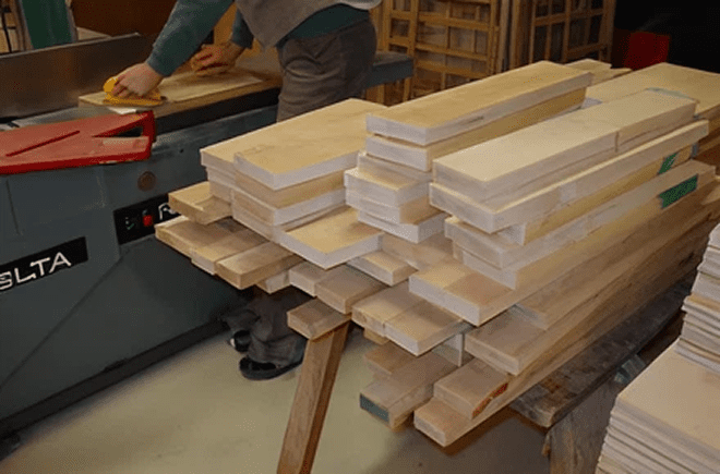 Stack of wooden planks in workshop.