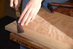 Woodworking with hand tool on wooden board.
