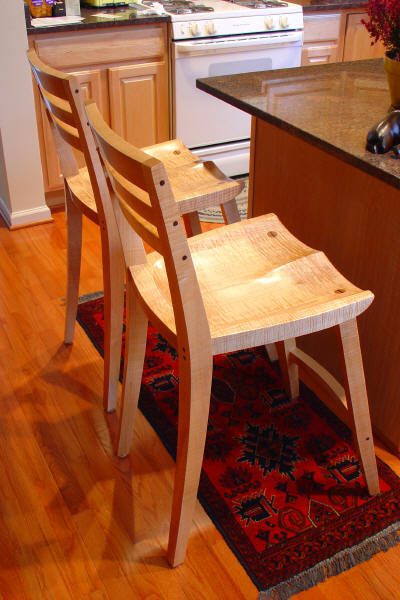 Wooden chairs by a kitchen island counter.