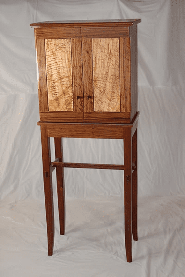 Tall wooden cabinet with intricate door patterns.