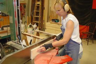 Woodworker using saw in a workshop.