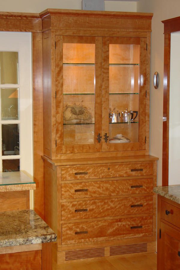 Wooden cabinet with glass doors and drawers.