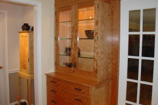 Wooden cabinet with glass doors and drawers.