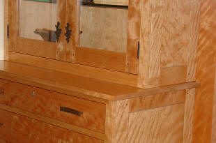Wooden cabinet with drawers and glass doors.