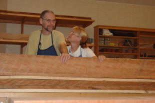 Two people woodworking in a workshop.