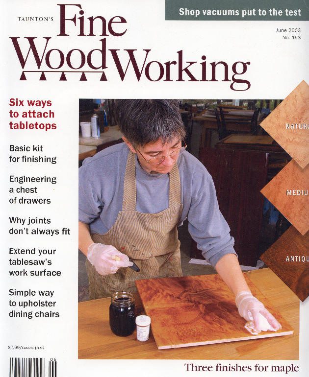 Person applying finish to wooden tabletop.
