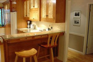 Cozy kitchen with wooden cabinets and stools.