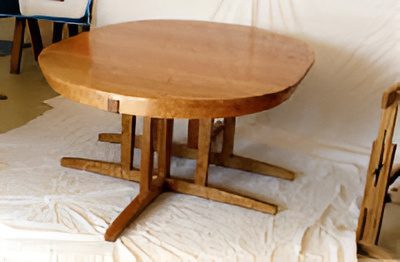 Round wooden table on white surface.