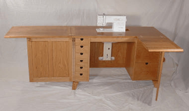 Wooden sewing cabinet with sewing machine.