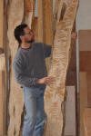 Man examining large wooden boards indoors.