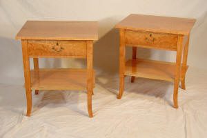 Two wooden side tables with single drawers and lower shelves, placed on a white cloth background.