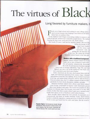 A handcrafted wooden bench with a curved seat and tall vertical back slats is featured next to an article titled "The virtues of Black.